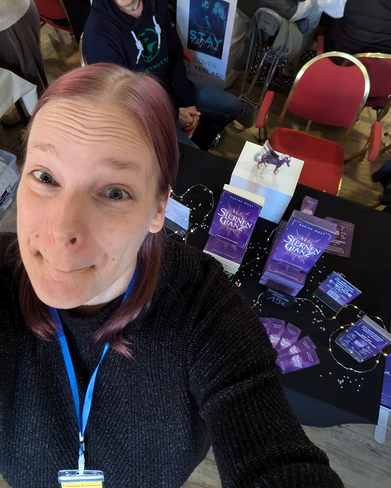 Nadine hinter Messetisch auf der Buch Berlin 2023